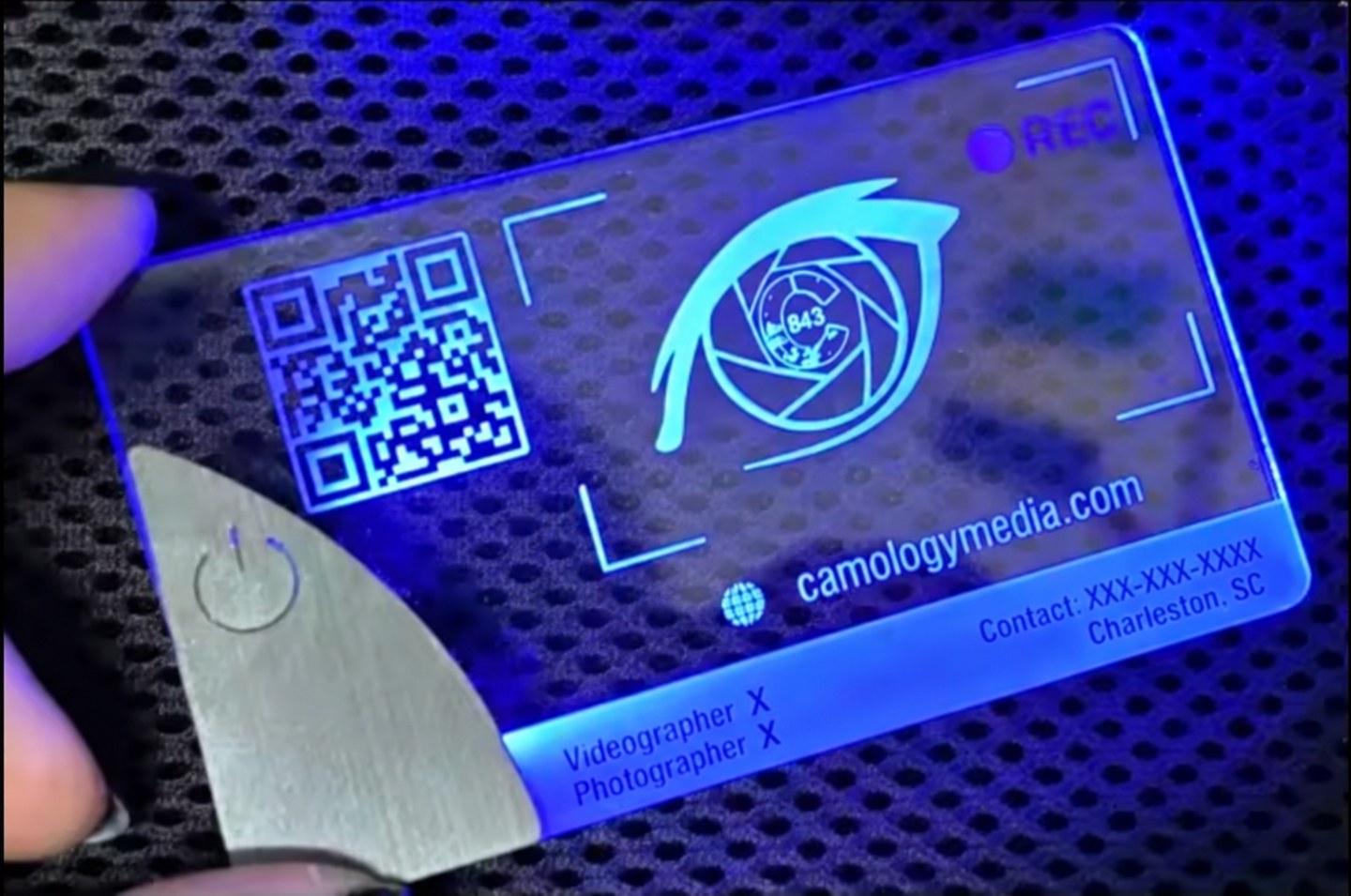 Camology Media sample business card with blue illumination on a mesh surface and X placeholders