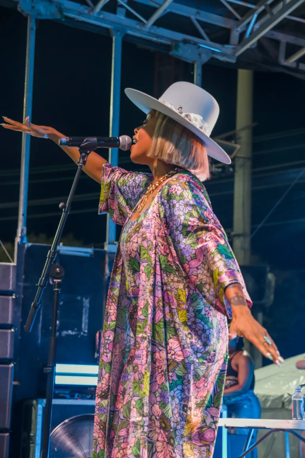 Live singer in a white hat performing at a microphone, photographed by Camology Media